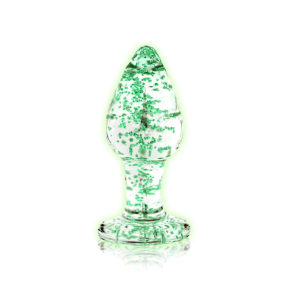 Clear glass anal plug glowing in the dark on a white background