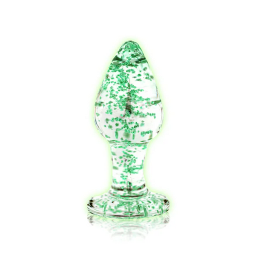 Clear glass anal plug glowing in the dark on a white background